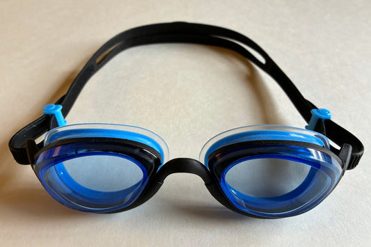 Front view of limited edition goggles with black frames and strap, and light blue lenses