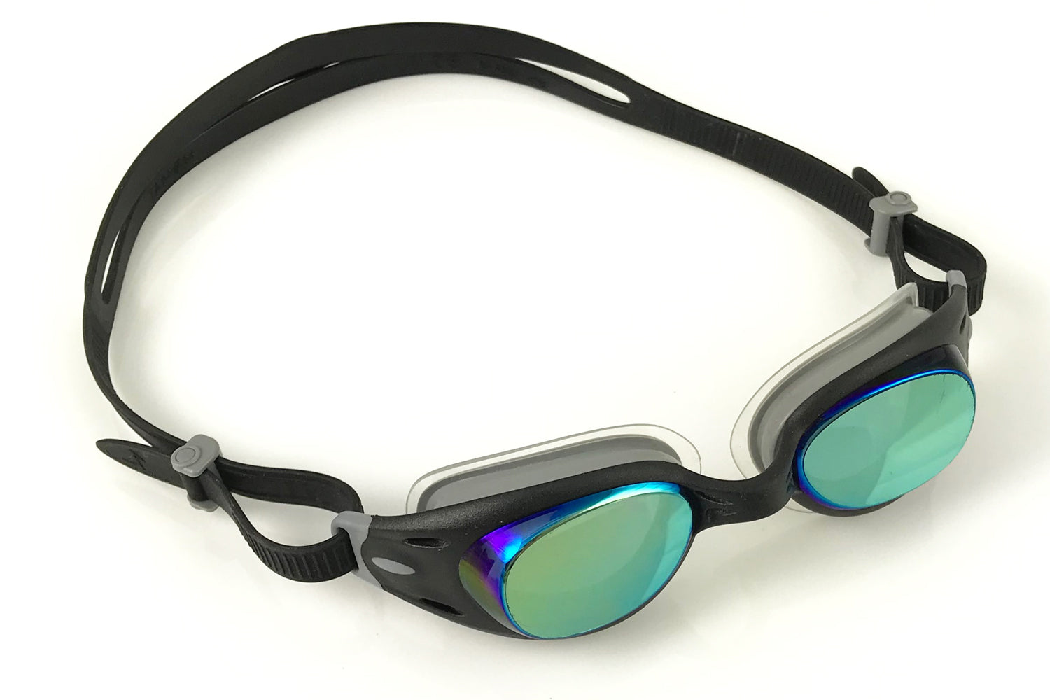 Black junior basilisk goggles with a dark tint, sitting on a white surface