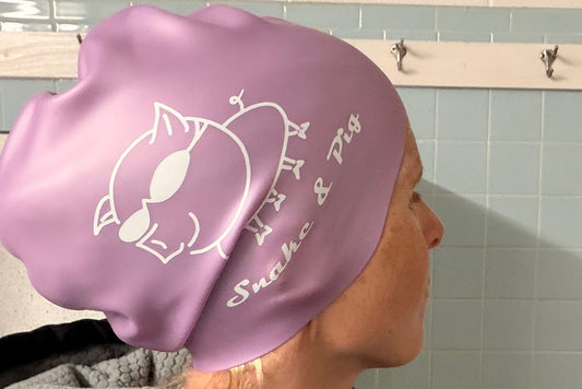 Woman with waist-length hair wearing small braid cap showing the large size of the opening and volume of the cap.