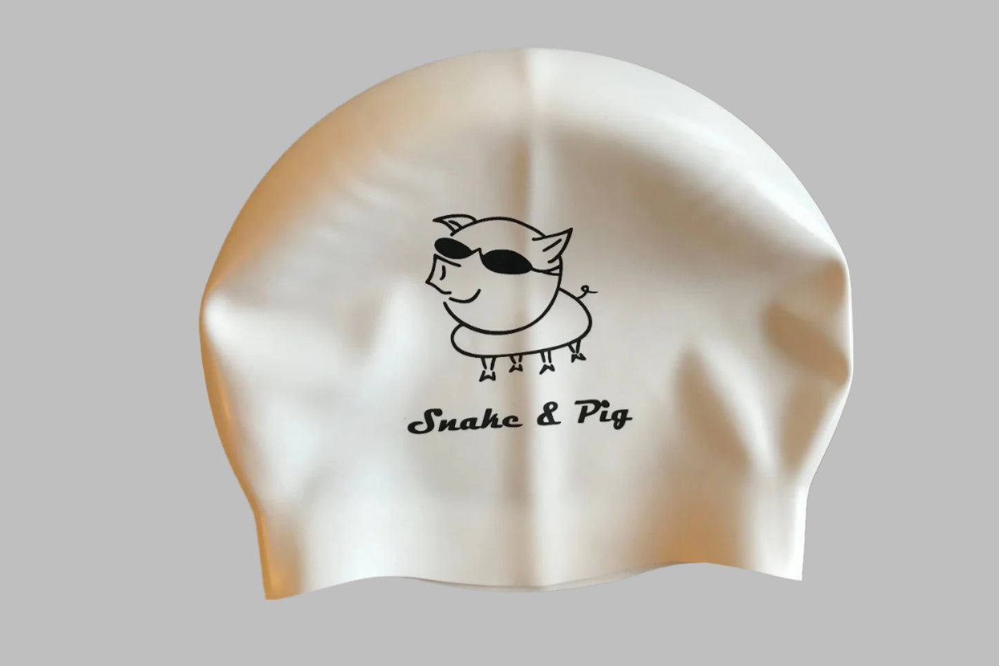 White silicone cap with black print. Snake & Pig in script font under a big pig wearing swim goggles.