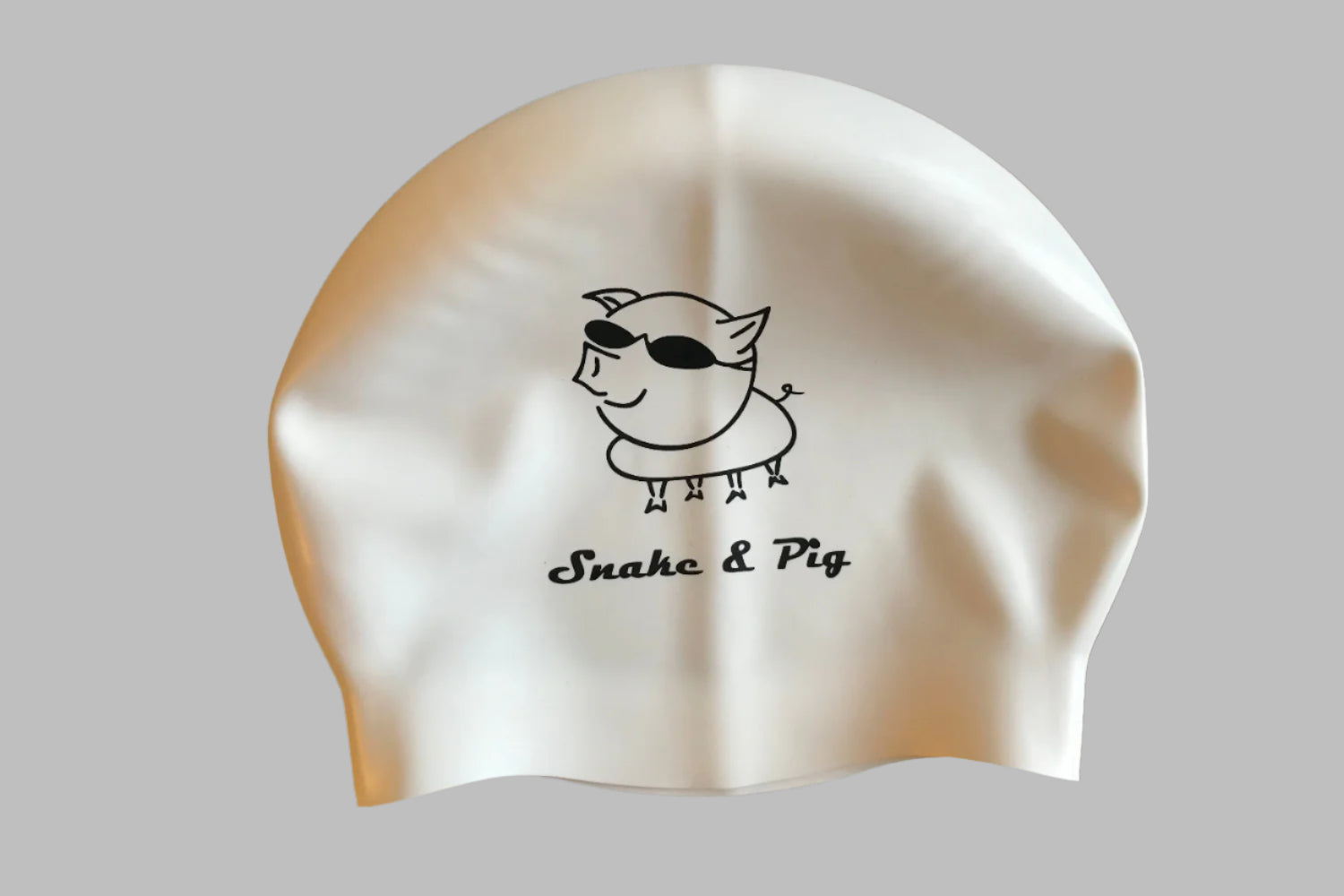 White silicone cap with black print. Snake & Pig in script font under a big pig wearing swim goggles.