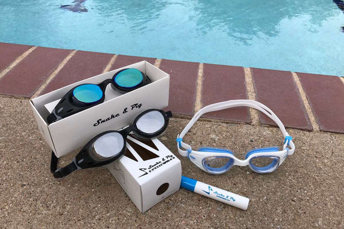 Snake & Pig Junior Basilisk swimming goggles in three tints on the pool deck