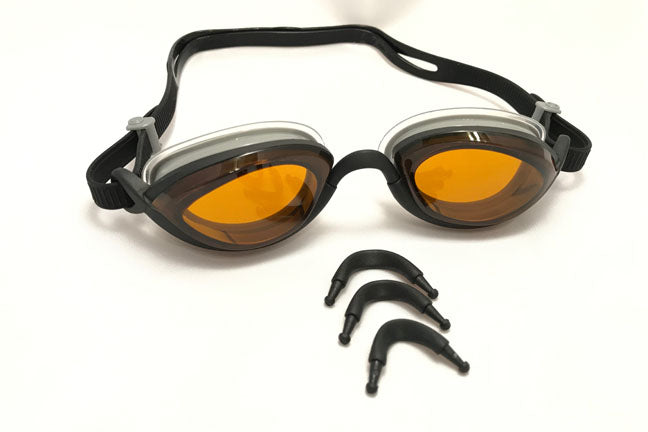 Three exchangeable nose pieces shown in front of a pair of amber Snake & Pig goggles