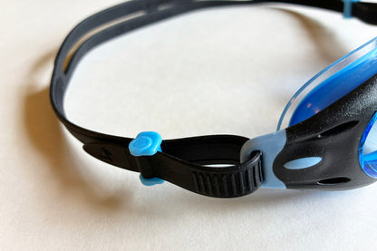 Close-up of a black and blue swim goggles on a light background